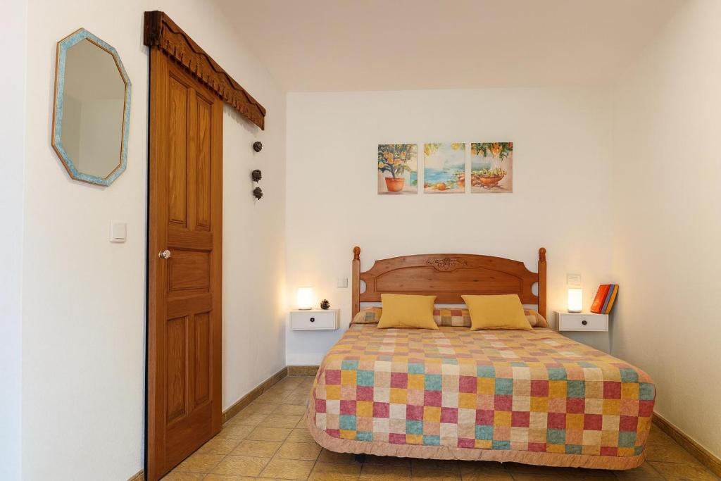 Un dormitorio con una cama y un espejo en la pared. en Casa Dace Renovated Studio - Fast Wi-Fi, 4-min Drive to Beach, Pet Friendly, en San Nicolás