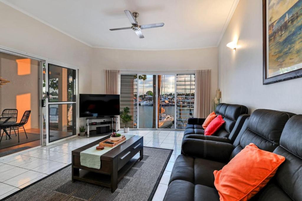 a living room with a couch and a tv at Cullen Bay Perfection in Larrakeyah
