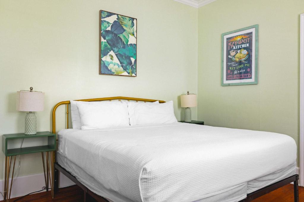 une chambre avec un grand lit blanc avec deux lampes dans l'établissement Key Lime Cottage, à Key West