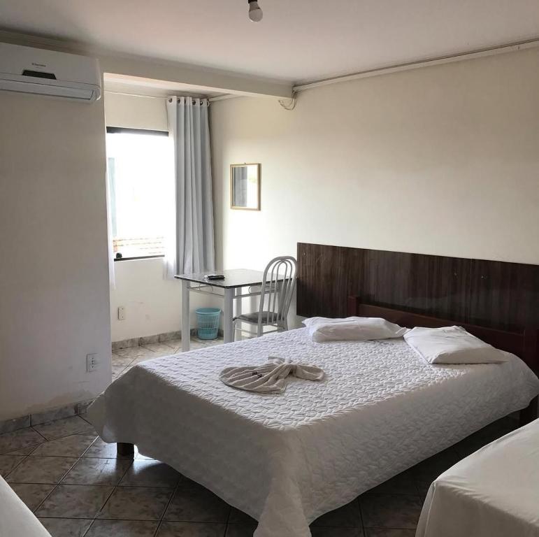 een slaapkamer met een bed met een handdoek erop bij Hotel Rio do Ouro in Porangatu
