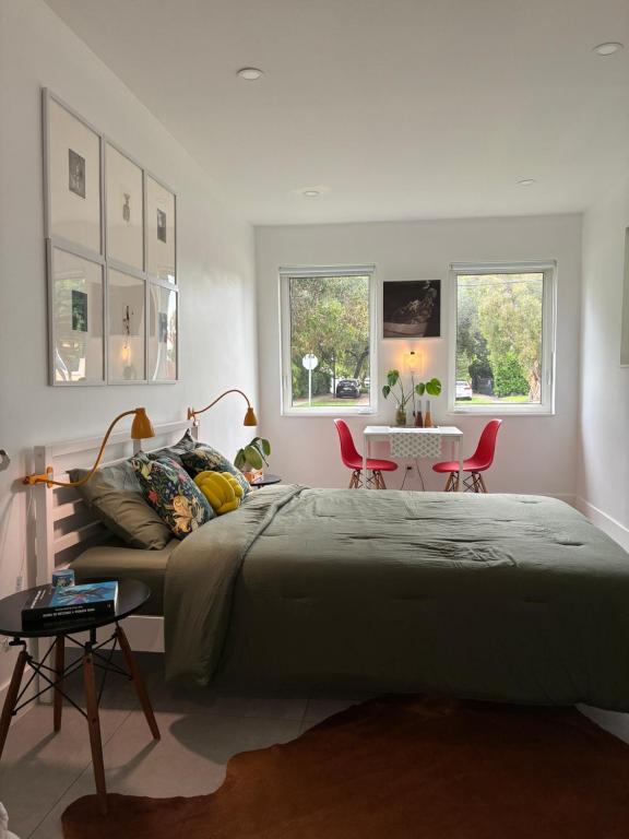 a bedroom with a large bed and two red chairs at Charming guest studio in the heart of Miami in Miami