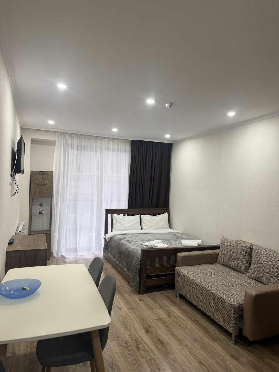 a bedroom with a bed and a couch and a table at Apartment N111 Loft 2 in Gudauri