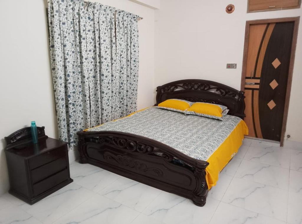 ein Schlafzimmer mit einem Bett mit zwei gelben Kissen in der Unterkunft Haven Apartment in Dhaka