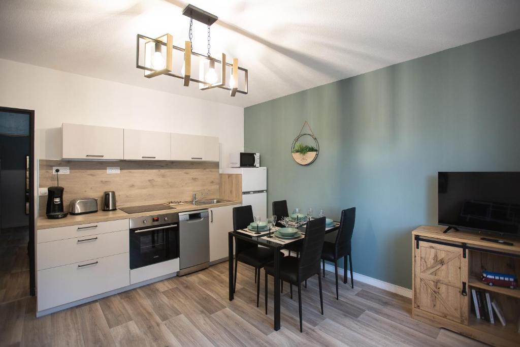 a kitchen with a table with chairs and a dining room at Vercors et Vous in Saint-Jean-en-Royans