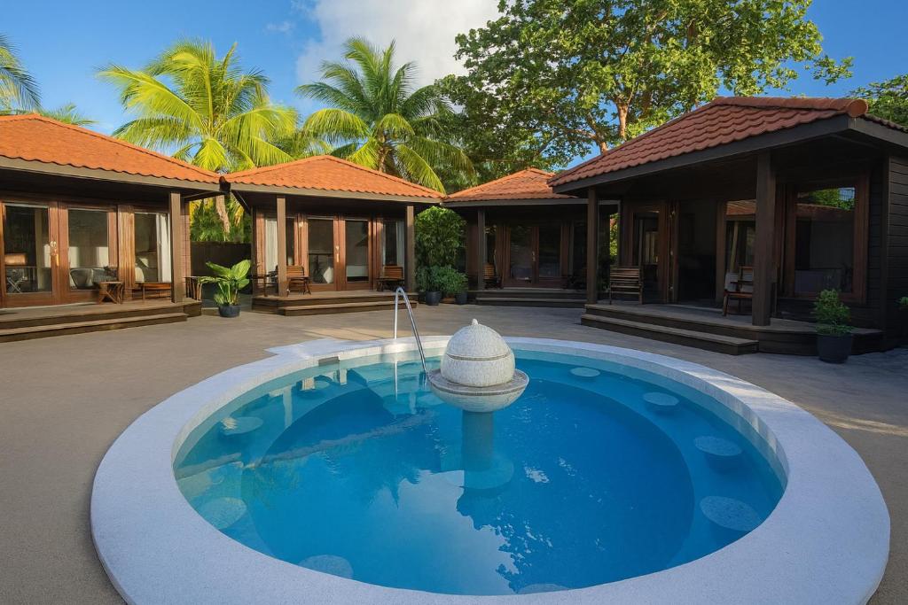 una piscina frente a una casa con una fuente en Marbucks Bed & Breakfast, en San Pedro