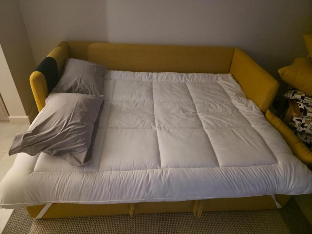 a bed with white sheets and pillows on it at ElGouna, Elegant 1Bedroom, private patio in Fanadir Marina in Hurghada