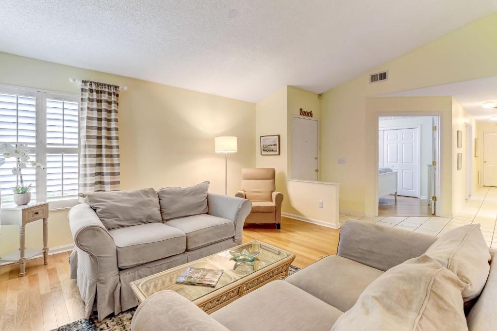 a living room with two couches and a table at 3 bedroom, 2 bath bungalow home in American Beach