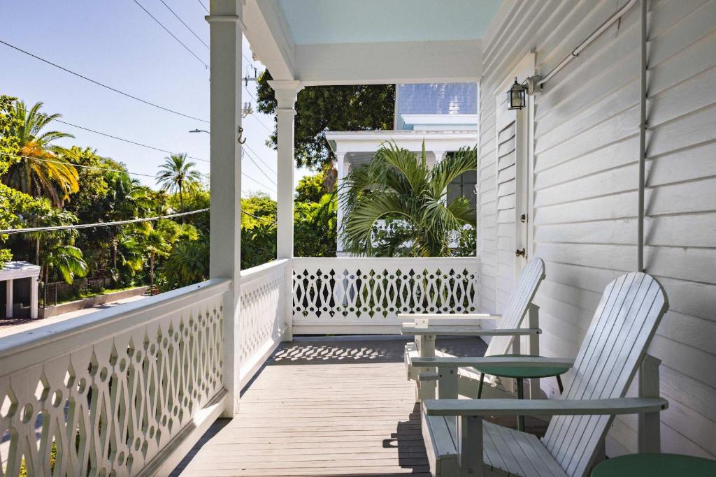 a porch with two chairs and a table at Creme Brulee Suite in Key West