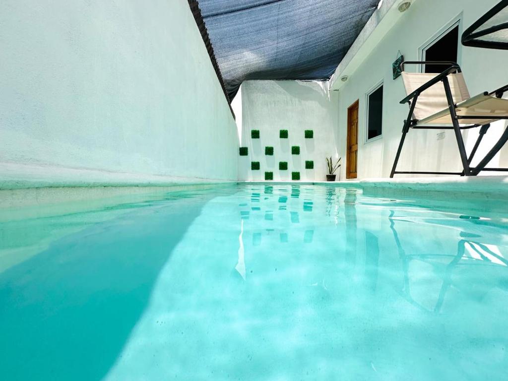 a swimming pool with a chair in a building at Apartamento de playa con piscina privada in Monterrico