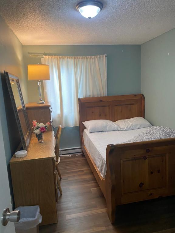 Un dormitorio con una cama y una mesa con una lámpara. en Comfy Private Room, en Brampton