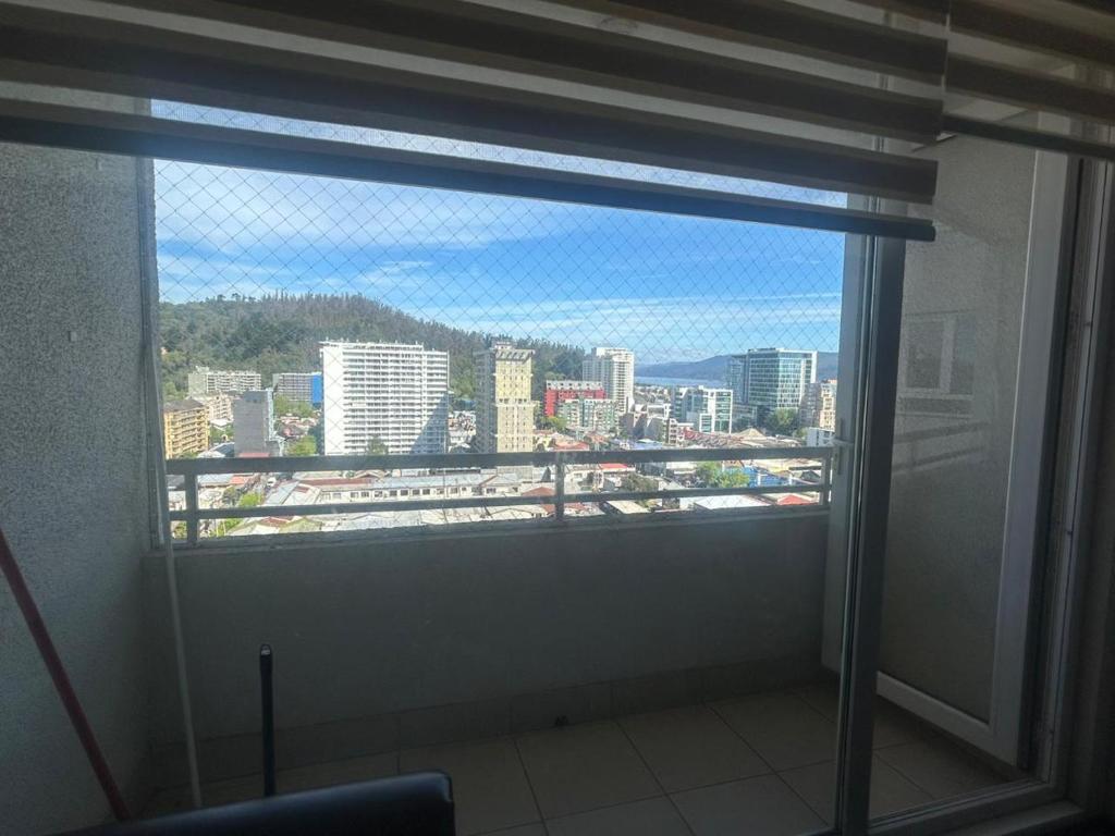 a window in a room with a view of a city at Departamentokilaman in Concepción
