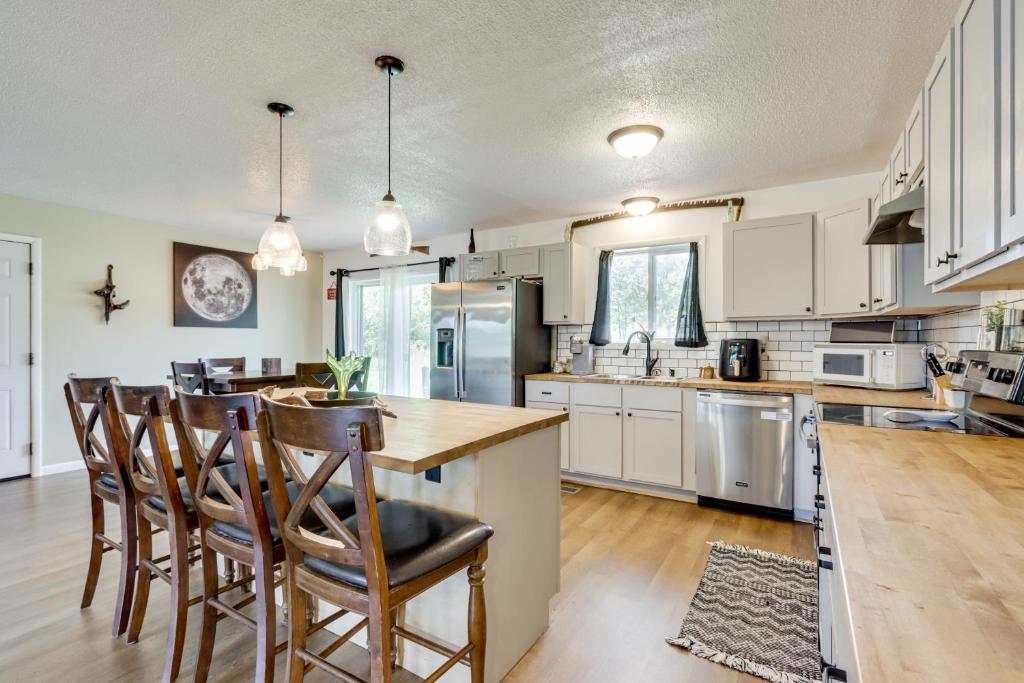 a kitchen with white cabinets and a table and chairs at 1 Mi to Shops and Cafes Updated Cassville Home! in Cassville