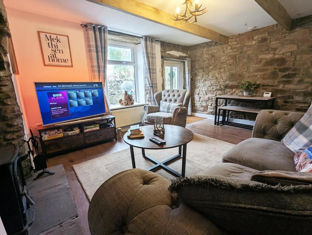 ein Wohnzimmer mit Couch und Fernseher in der Unterkunft Beautiful Waterfall Cottage with Countryside Walks in Barnoldswick