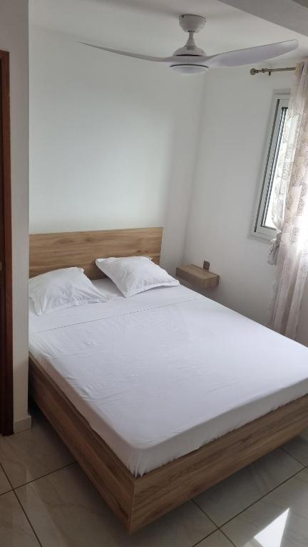 a bedroom with a large bed with a white mattress at Maison f2 rouge in Saint-Leu