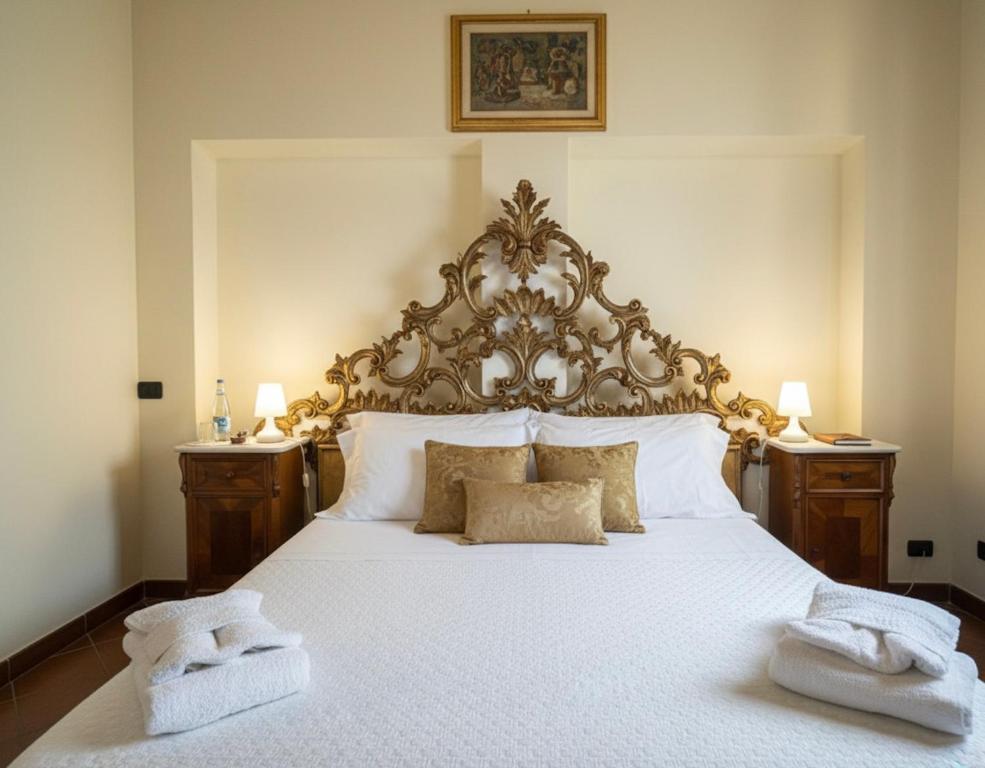 a bedroom with a large bed with two towels on it at Le Dimore della Seta in Lucca