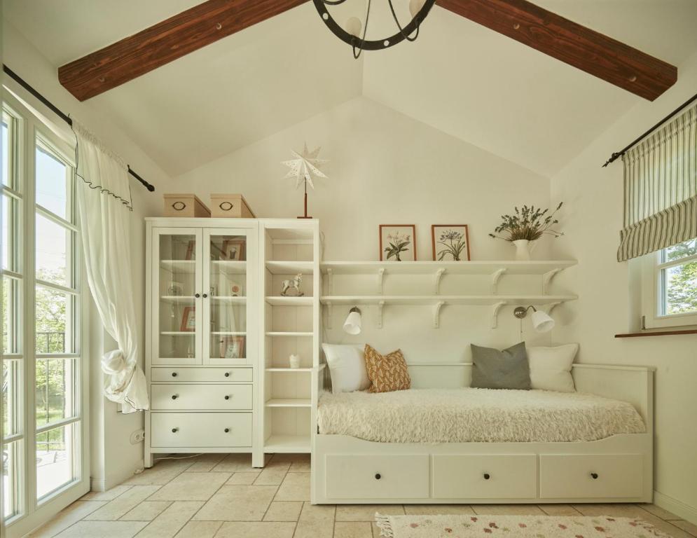 a bedroom with a white bed and a white cabinet at Nad svatým Kiliánem 