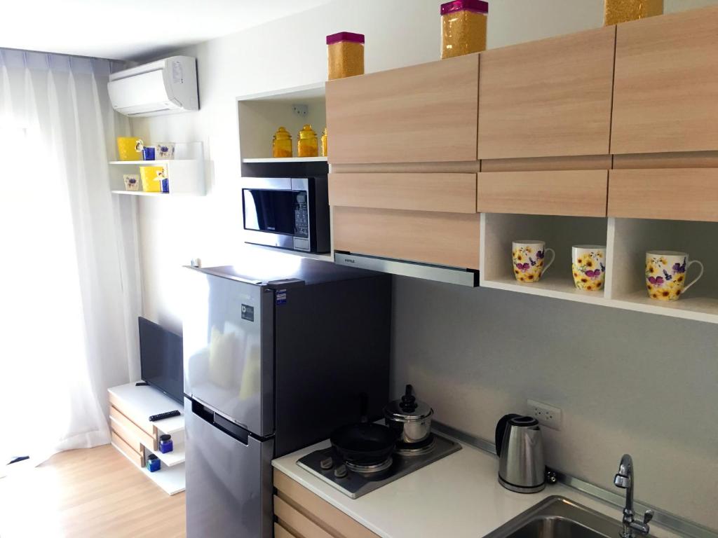 a small kitchen with a refrigerator and a microwave at Happy Place Official in Nai Yang Beach