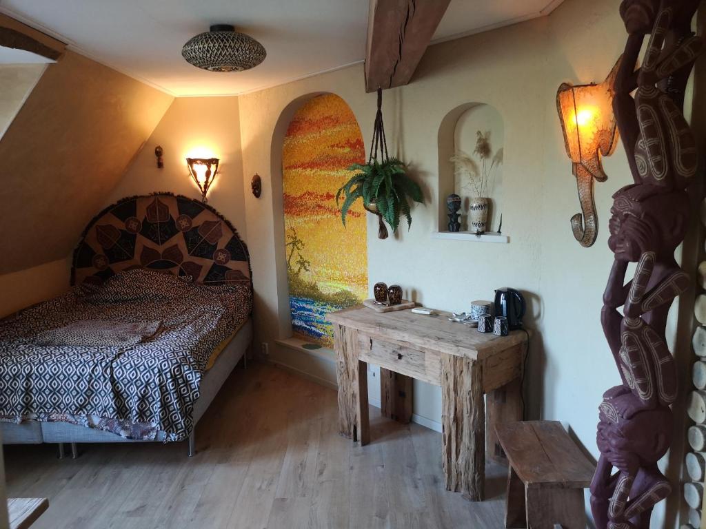 a bedroom with a bed and a wooden table at South African Room in Westbeemster