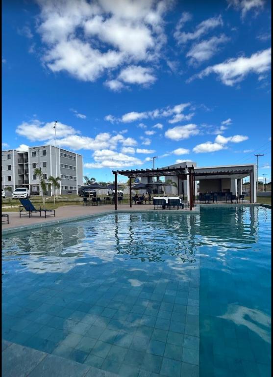 a swimming pool with a pavilion and a blue sky at Apto com dois quartos com cama e ar in Juazeiro do Norte
