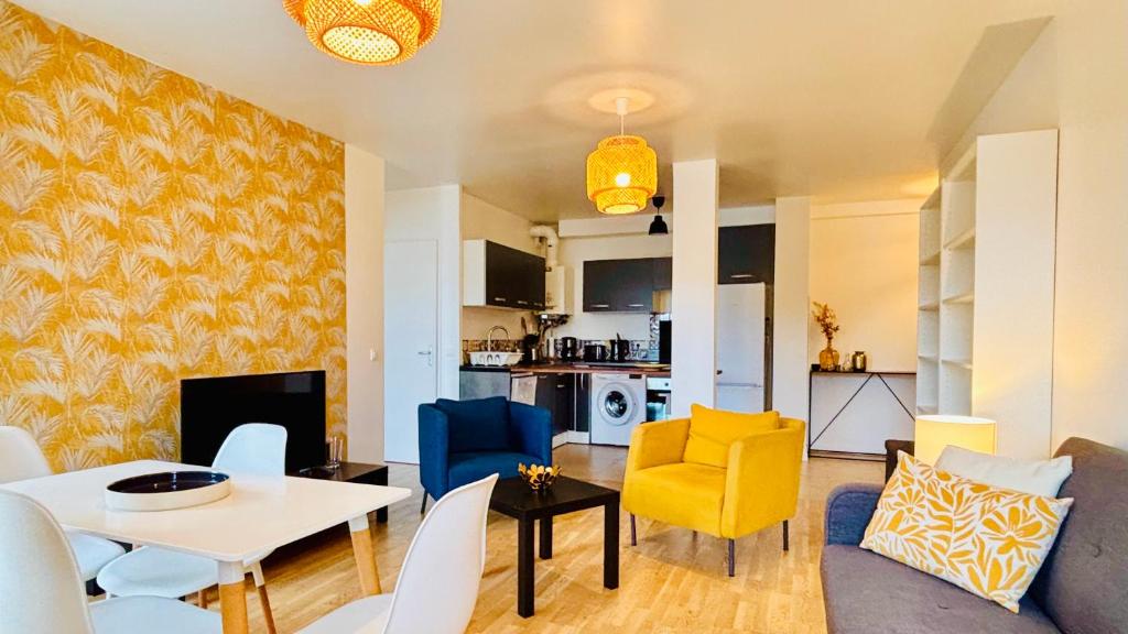 a living room with a couch and a table and chairs at Appartement Cosy et calme - face à la gare Rosny-sous-Bois - 20mn de Paris et Disneyland in Rosny-sous-Bois