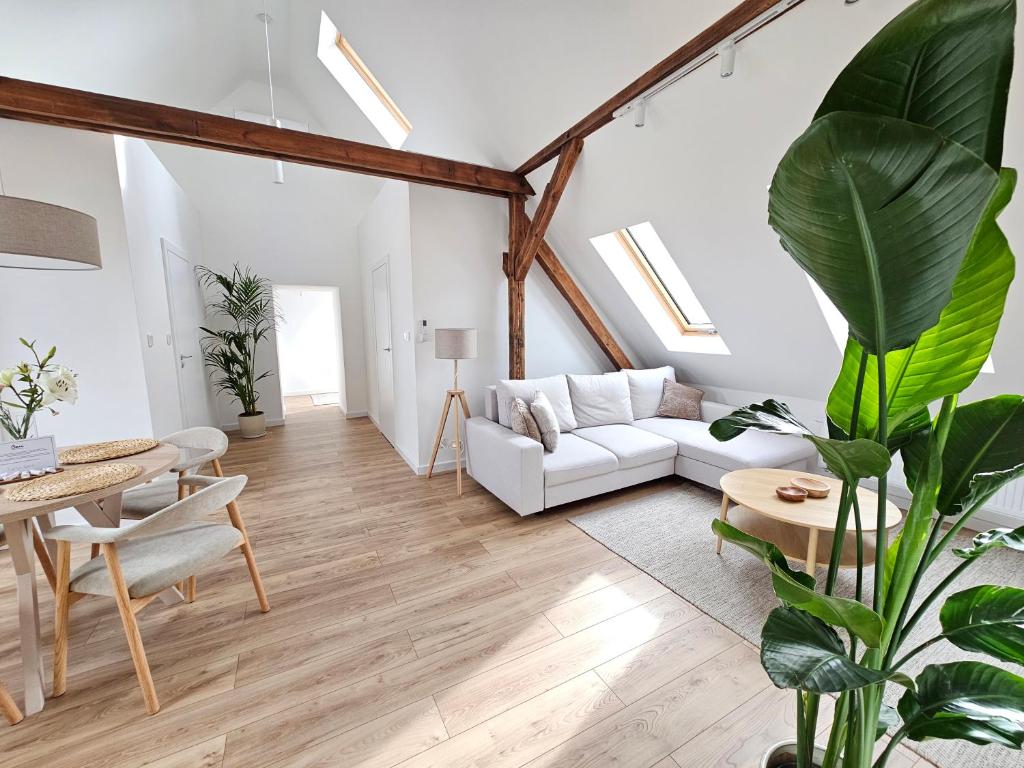 a living room with a white couch and a table at Apartamenty SWAN in Gliwice