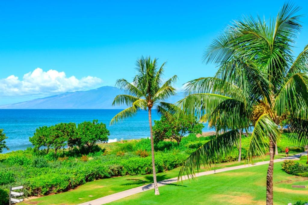 une vue sur l'océan depuis un complexe hôtelier avec des palmiers dans l'établissement Honua Kai 3 Free Rental Cars KBM Resorts Ocean Front 3 Units 6 Bedrooms HK ML-1119, à Kaanapali Airport