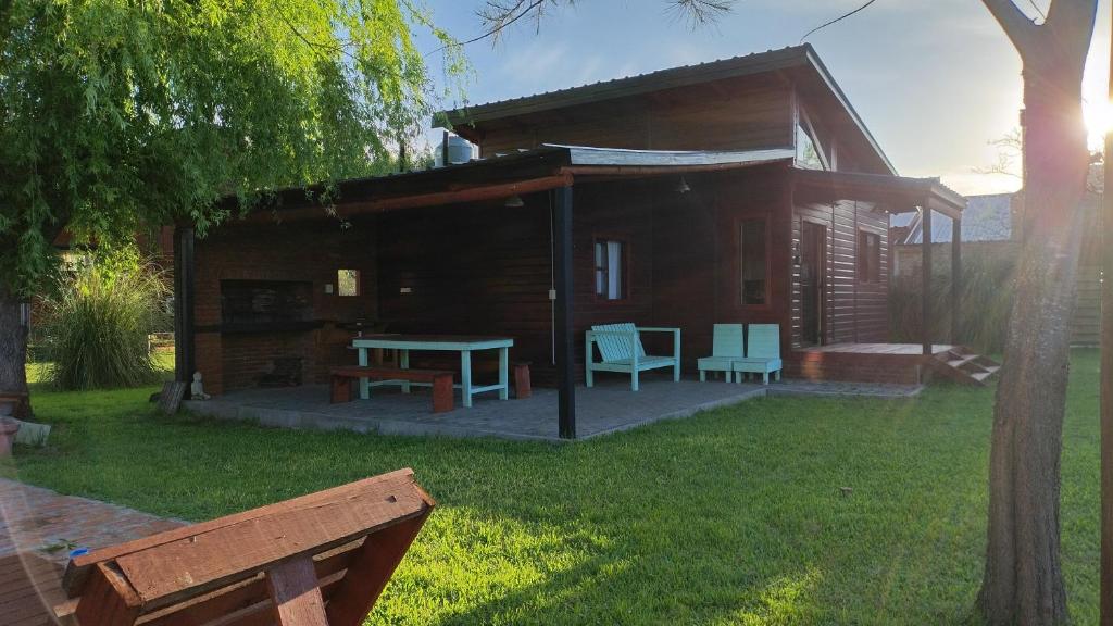 a cabin with a table and chairs in the yard at Cabañas Entre Rios in Concepción del Uruguay