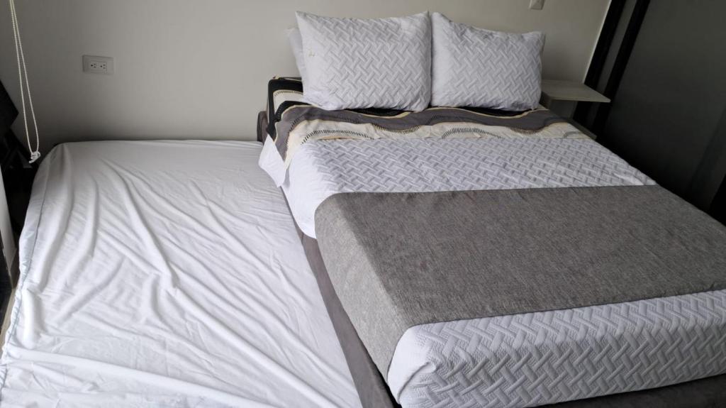 una cama con dos almohadas encima en Tropical Oasis Suite, en Santa Marta