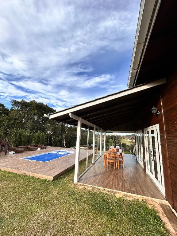 a patio with a deck and a swimming pool at Cabana Guimarães in Rancho Queimado