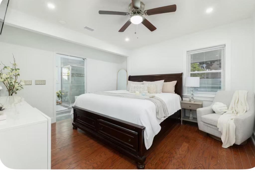 1 dormitorio con 1 cama, ventilador de techo y silla en Encanto del sur, en Charleston