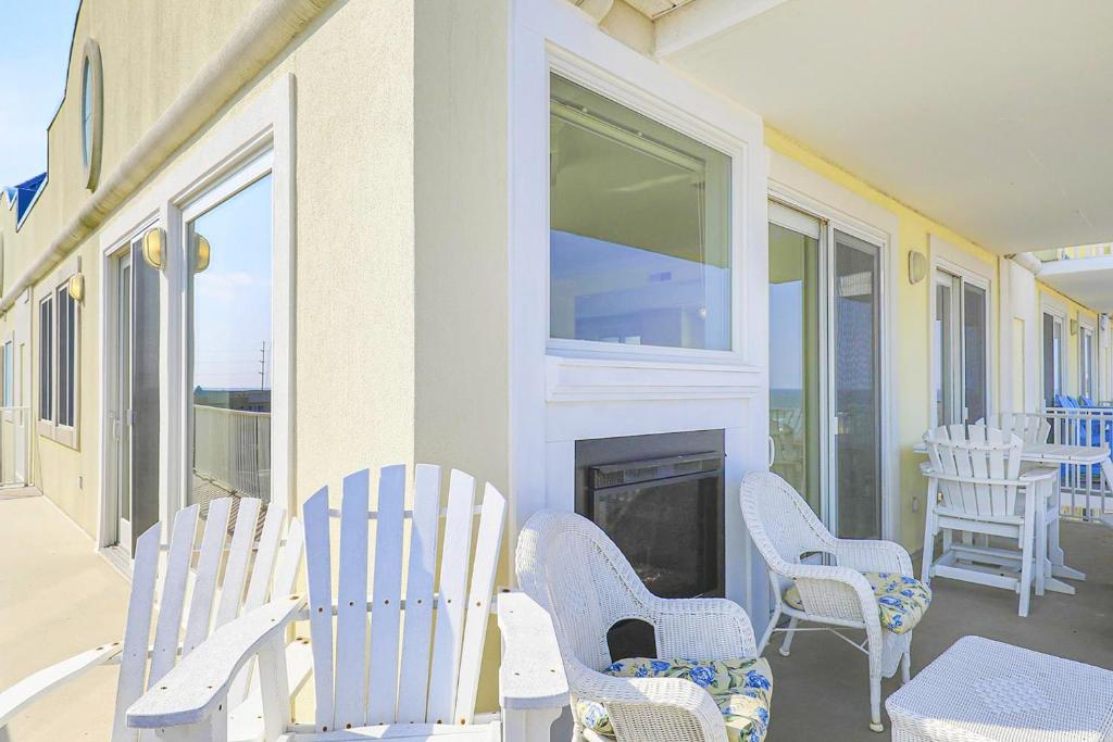 a porch with white rocking chairs and a fireplace at Adagio 503 in Ocean City