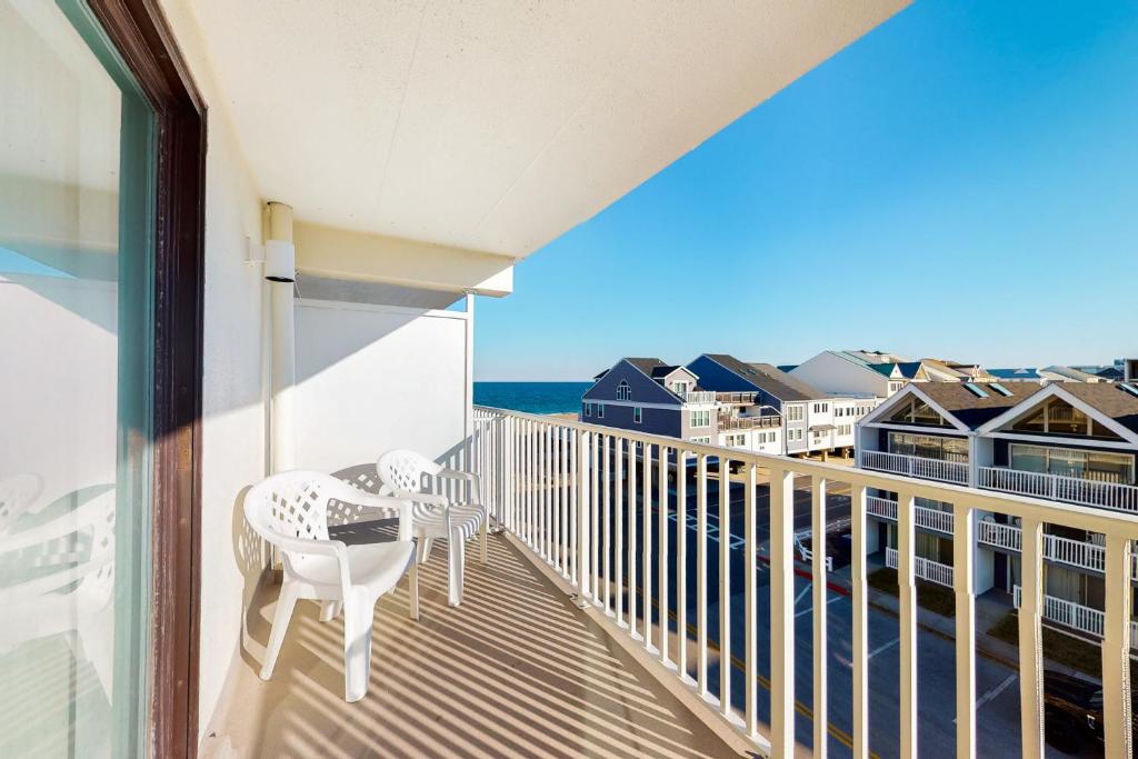 a balcony with a table and chairs and the ocean at Ocean Place 401 in Ocean City
