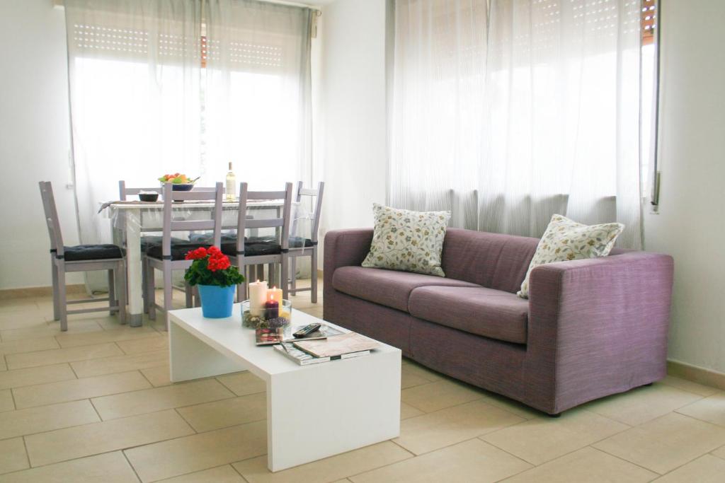 uma sala de estar com um sofá roxo e uma mesa em Orizzonte Mare em Fontane Bianche