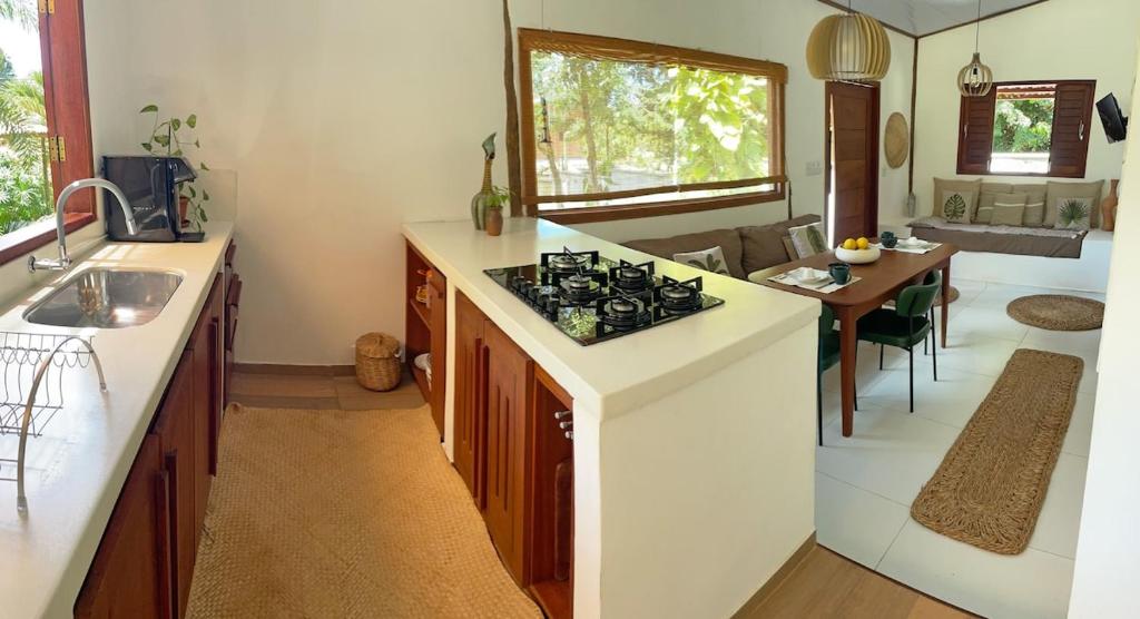 a kitchen with a stove and a dining room at Casa Positano Pipa in Pipa