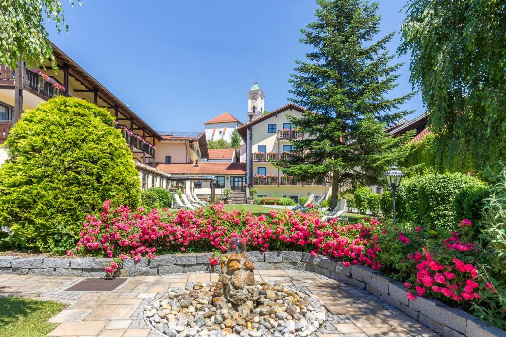 a garden with pink flowers and a fountain at Gräfliches Hotel Alte Post in Bad Birnbach