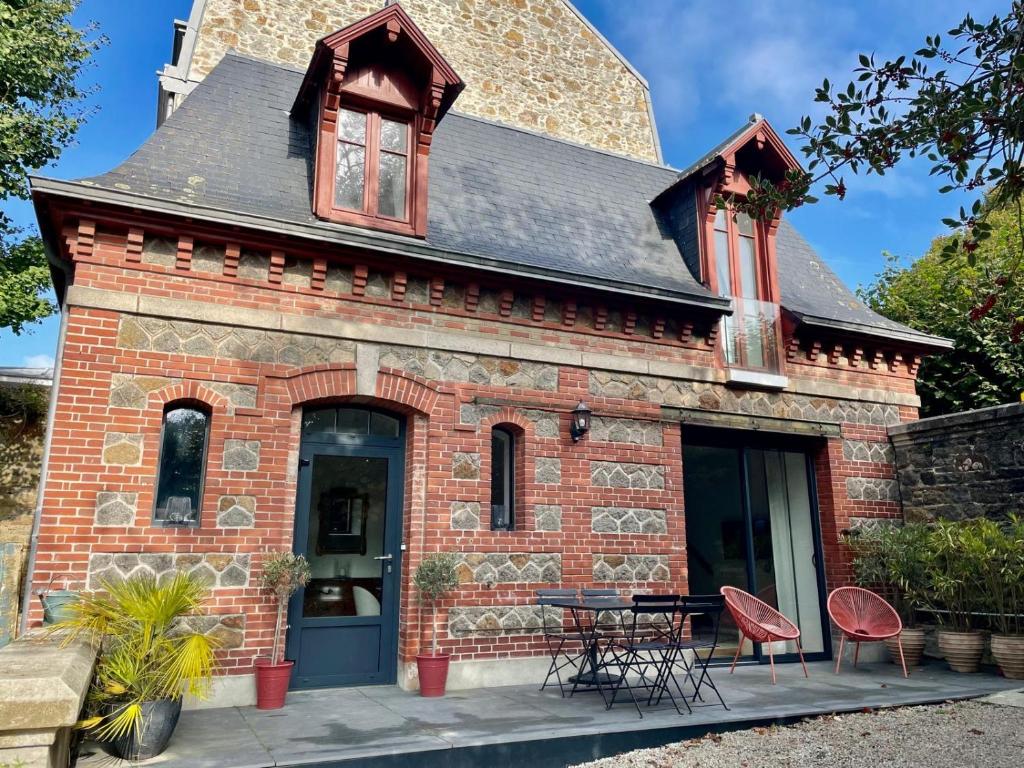 een oud bakstenen gebouw met een tafel en stoelen bij Charmante petite maison d'exception classée in Saint-Brieuc