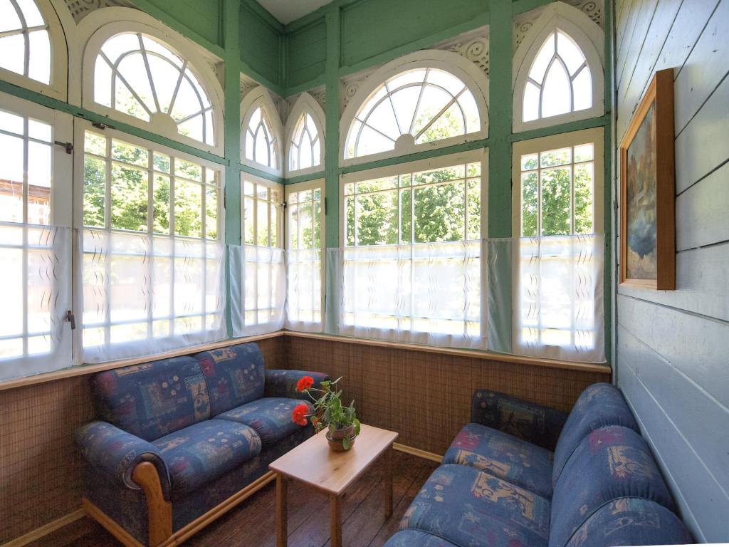 a living room with two blue couches and windows at Seaside Park Apartment in Liepāja