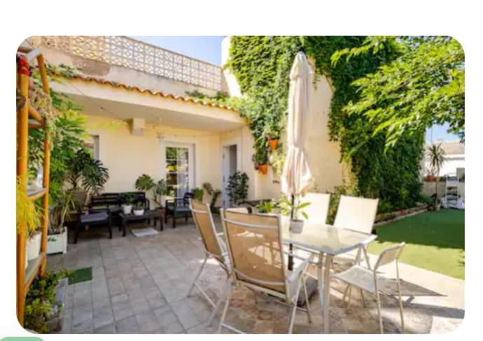 un patio con tavolo, sedie e ombrellone di Retales a Cartagena