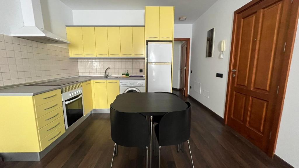 a kitchen with yellow cabinets and a black table at la casa de pozo1 in Pozo Izquierdo