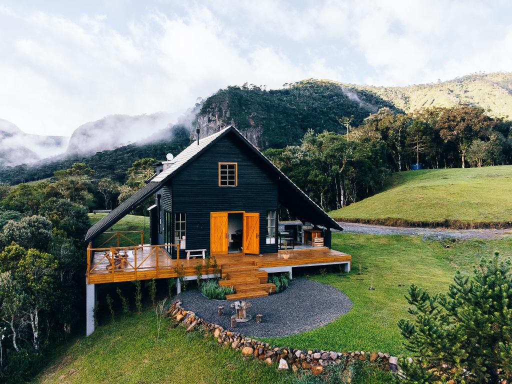 a house on a hill with mountains in the background at Chalé Exclusivo com Spa e Vista Mágica, Top Urubici in Urubici