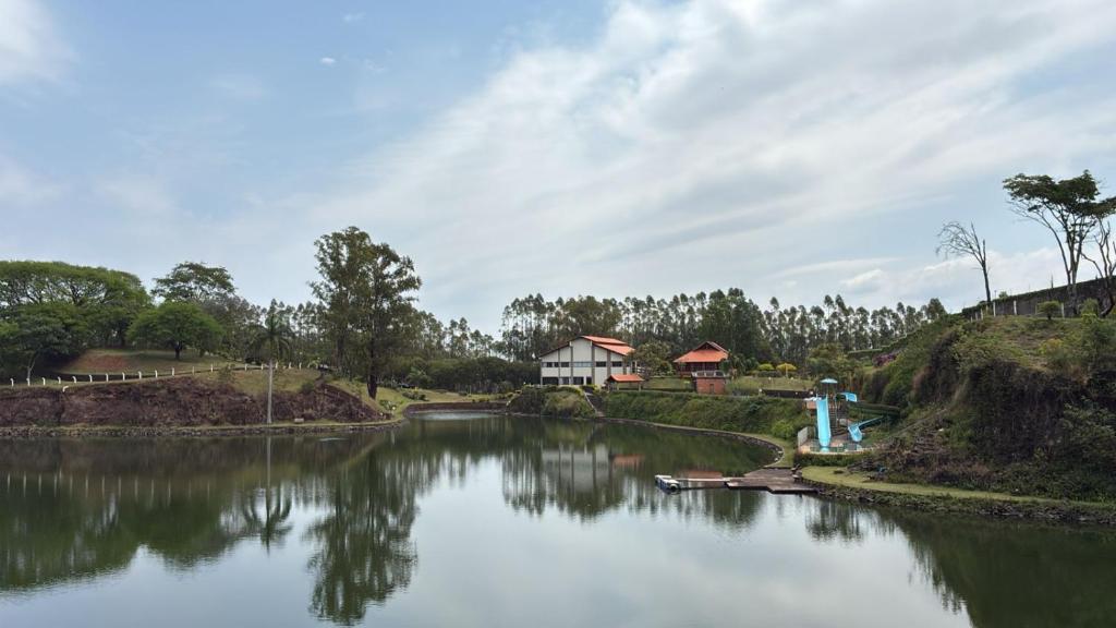 a view of a river with a house in the background at Hotel Lago Alphaville in Apucarana