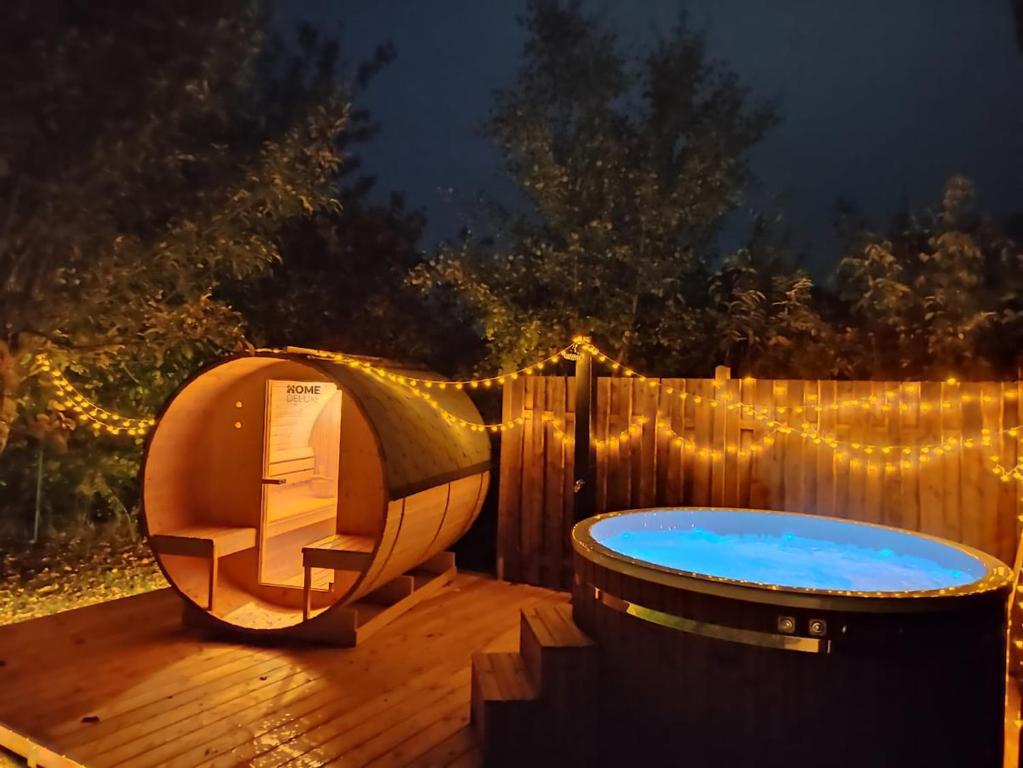 a hot tub sitting on a deck at night at Eulennest im Ferienhaus an der Holzecke in Schnelldorf