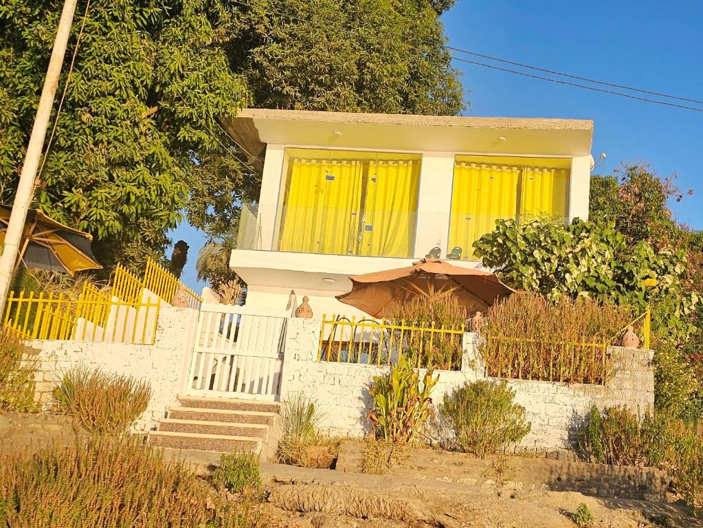 a house with yellow windows and a fence at Esmerada in Aswan