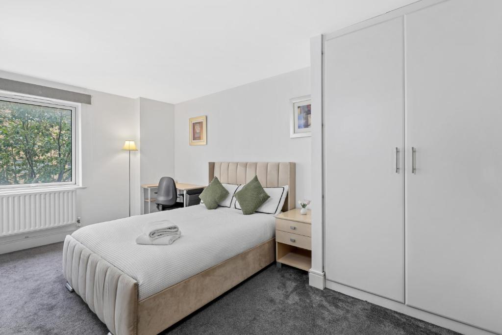 a bedroom with a bed and a desk and a window at Ensuite Room in Canary Wharf with attached Bathroom in London
