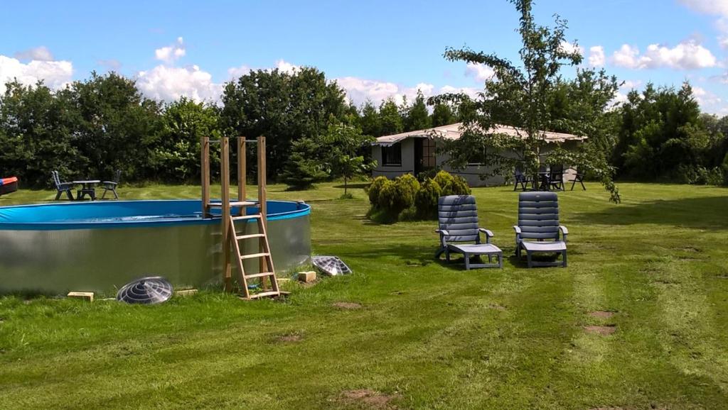 eine Gruppe von Stühlen neben einem Pool in der Unterkunft Ferienwohnung Boen in Boen