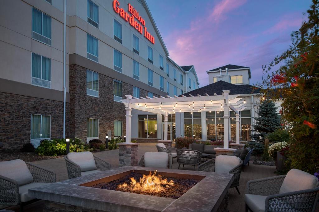 a hotel patio with a fire pit in front of a hotel at Hilton Garden Inn Cedar Falls Conference Center in Cedar Falls