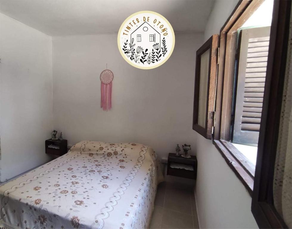 a bedroom with a bed and a clock on the wall at Tintes de otoño in Mina Clavero