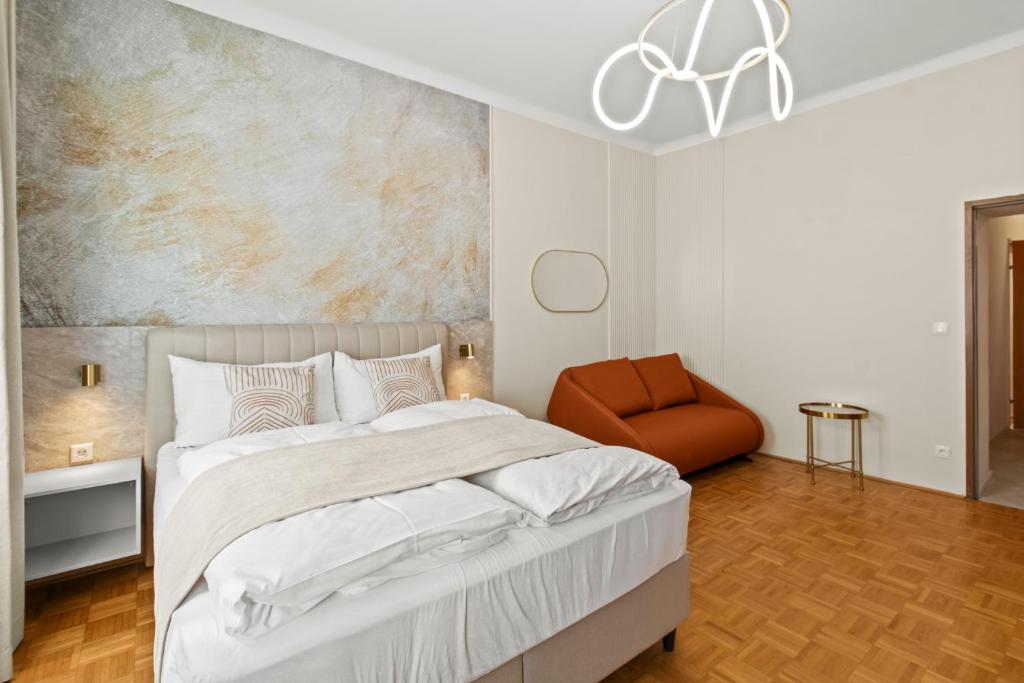 a bedroom with a large bed and a chair at 1 Min to U6 Niederhofstraße I Near Schönbrunn in Vienna