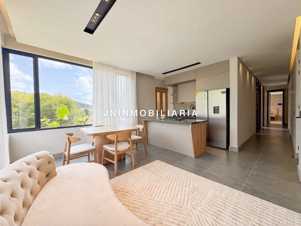 a living room with a table and a kitchen at Apartamento de lujo a 3 minutos del Aeropuerto JMC 302 in Rionegro