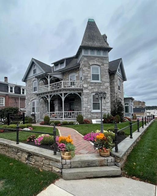 a large stone house with flowers in front of it at Willough Bed and Breakfast in Conshohocken